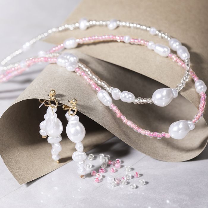Halsband och örhängen med pärlemorskimrande vita pärlor och rocaillepärlor