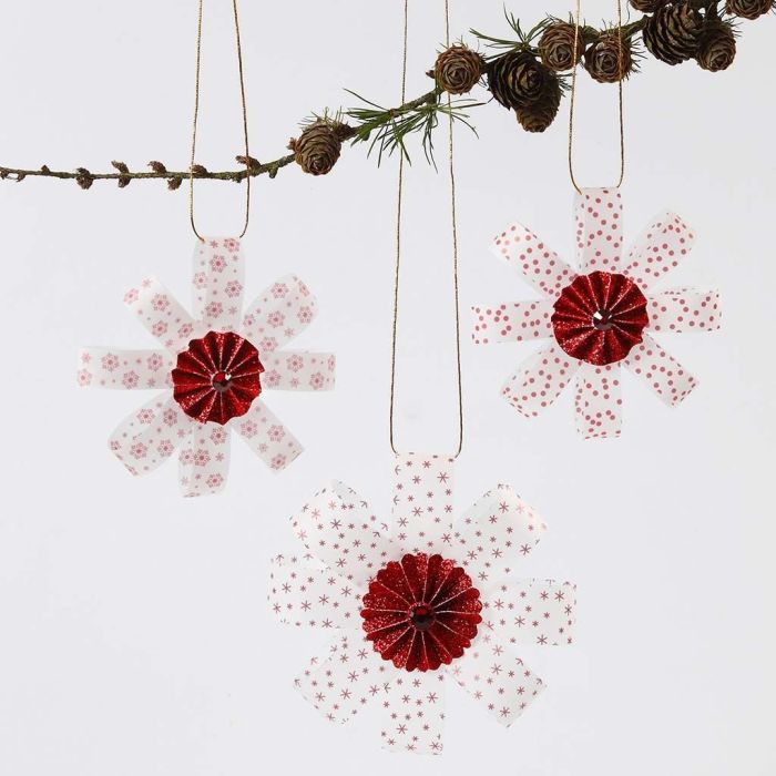 Dekorationer av stjärnstrimlor i vellumpapper med rosett i mitten och glitter