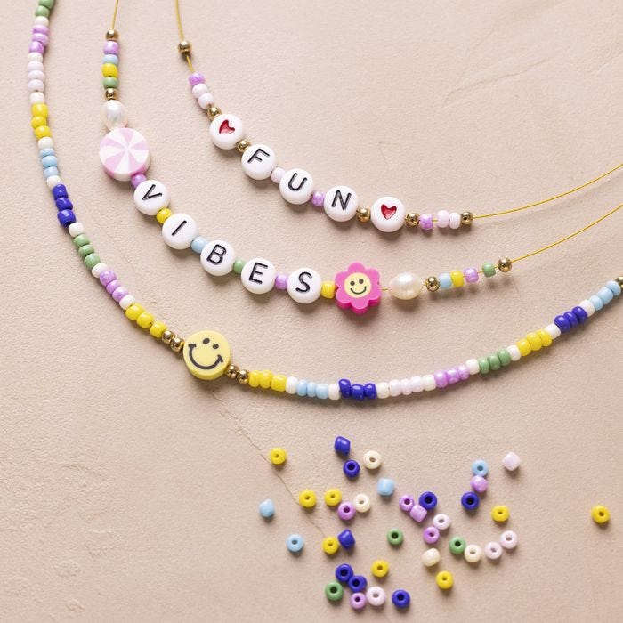 Pärlhalsband med bokstäver och figurer