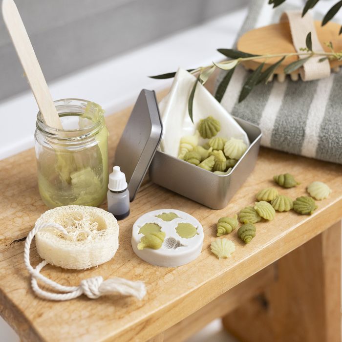 Resebehållare med små olivoljetvålar och loofah-svamp