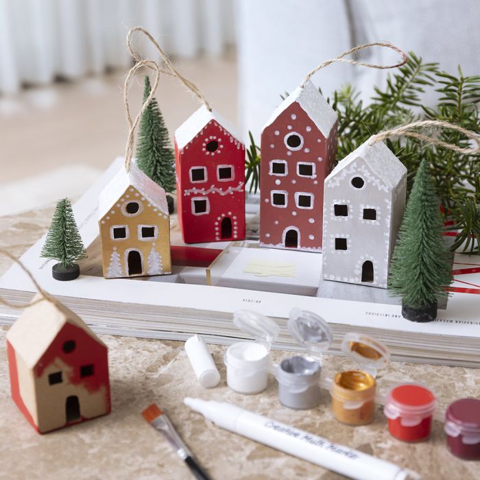 Målade julhus med snö ovanpå