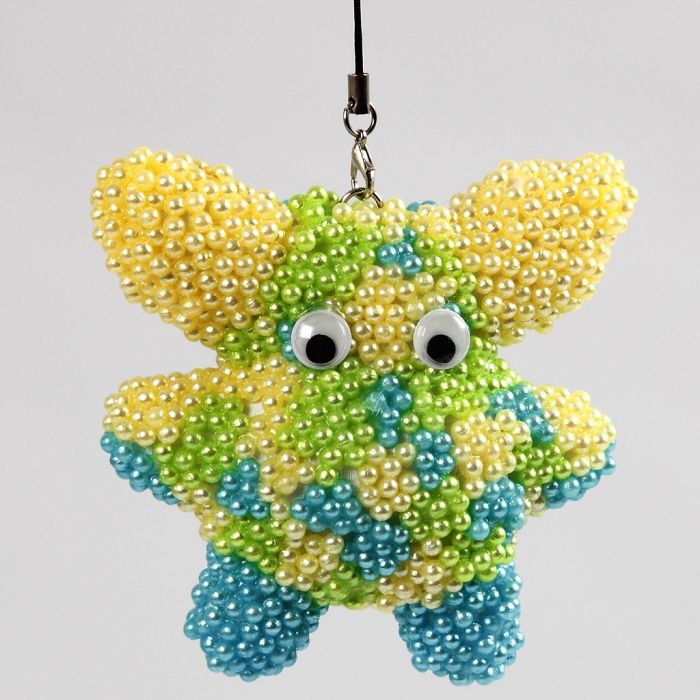 Tygfigur klädd med Pearl Clay och rullögon