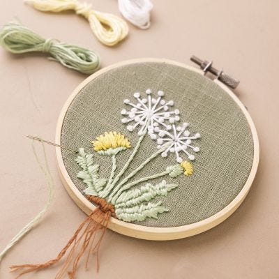 Broderbåge med broderad maskros