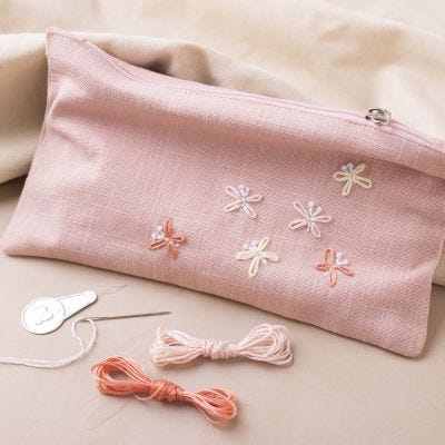 Clutch i skinnimitation med broderade fjärilar