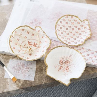 Snäckor dekorerade med decoupage och guldpenna 