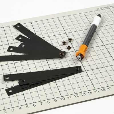 Dekoration av svarta lackstrimlor i öljett med lädersnöre