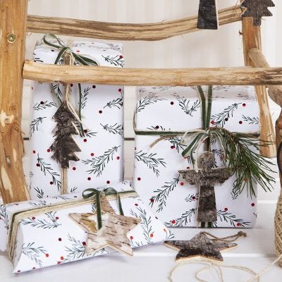 Julklappsinslagning med gröna grenar som motiv