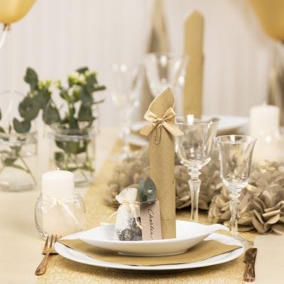 Bordsdukning och bordsdekoration i guld med pappersblommor