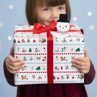 Julklappsinslagning med polarmotiv och pop-up snögubbe som presentetikett.