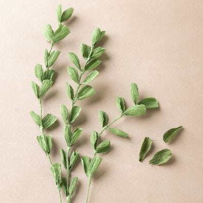Grenar med små blad av kräppapper