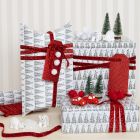 Julklappar dekorerade med pompoms och minifigurer