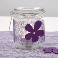 Ljusglas med bälte av lila nät och träblomma