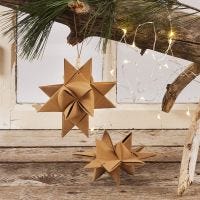 Julstjärna flätad av stjärnstrimlor av läderpapper med lädersnöre och träpärla
