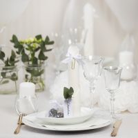 Bordsdukning och bordsdekoration i vit med pappersblommor, ballonger, servetter vikta som torn och bordskort.