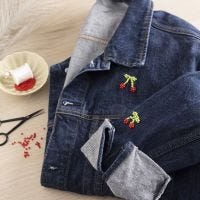 Pärlbroderade körsbär på jeansjacka