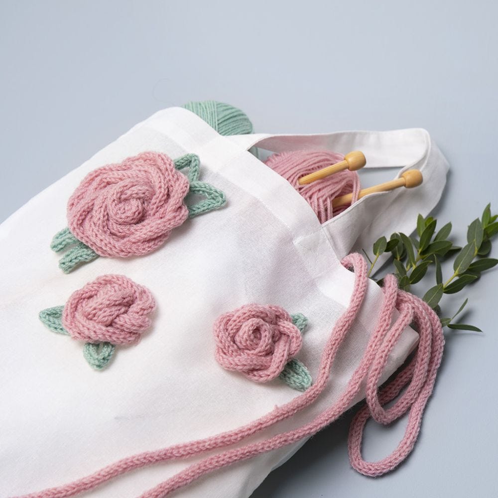 Textilkasse dekorerad med rosor gjord av stickade tuber