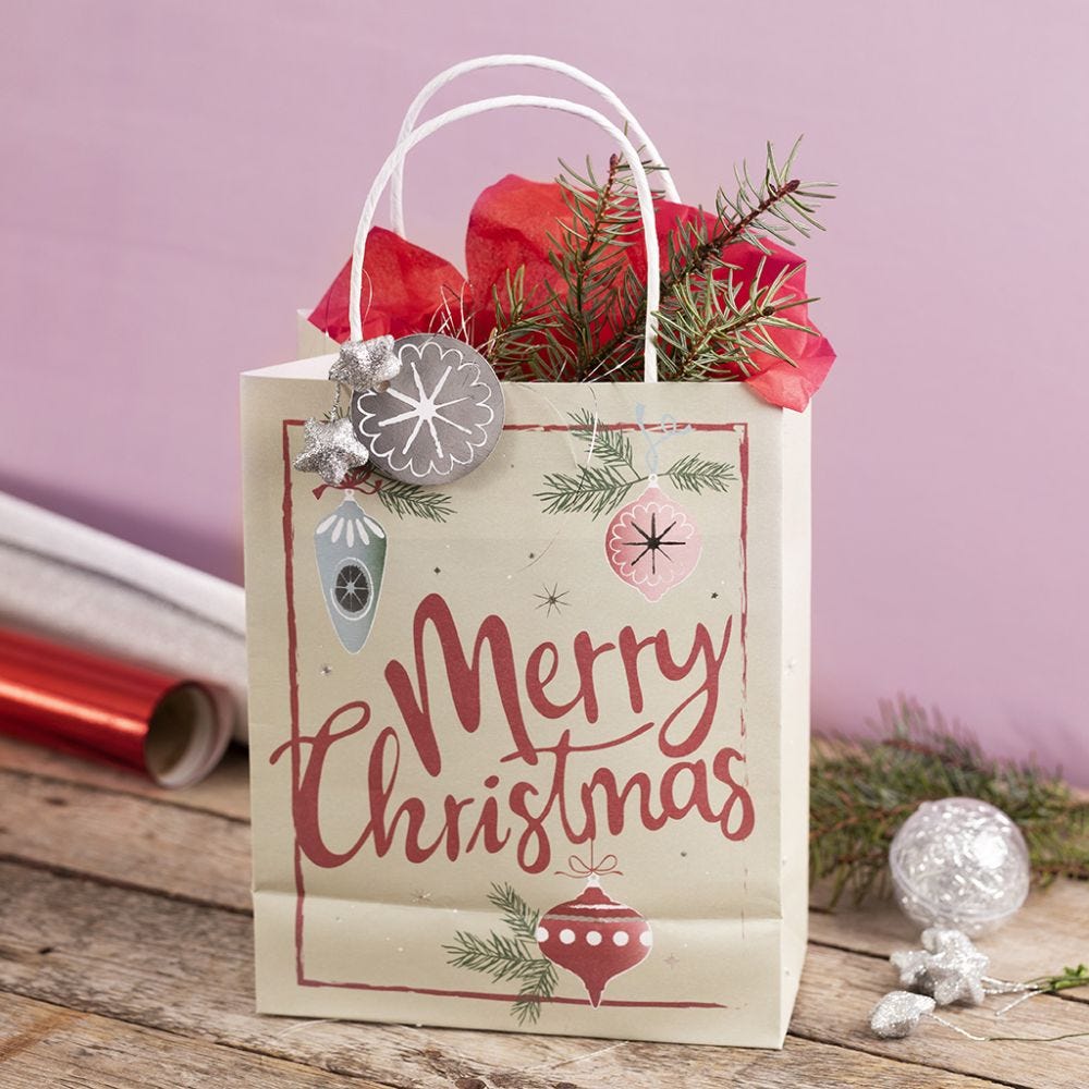 Presentpåse med julmotiv dekorerad med stjärna, lametta och silkespapper