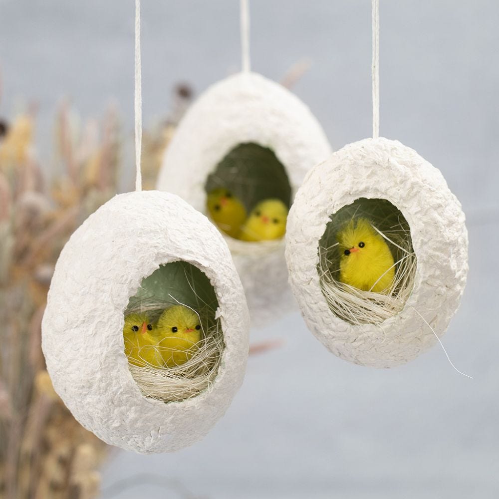 Påskägg av pulp med hål, dekorerad med kycklingar i rede